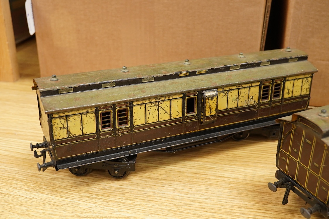 Three Carette for Bassett-Lowke 0 gauge tinplate GWR clerestory bogie coaches; two First Third Composite coaches, both 1324, and a full brake van, 1334, all in chocolate and cream livery
